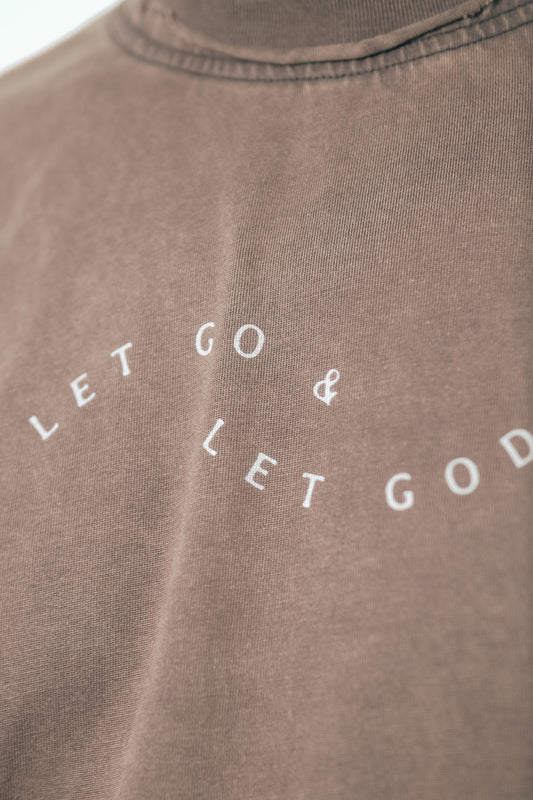 Front view of the Let Go & Let God brown t-shirt being worn