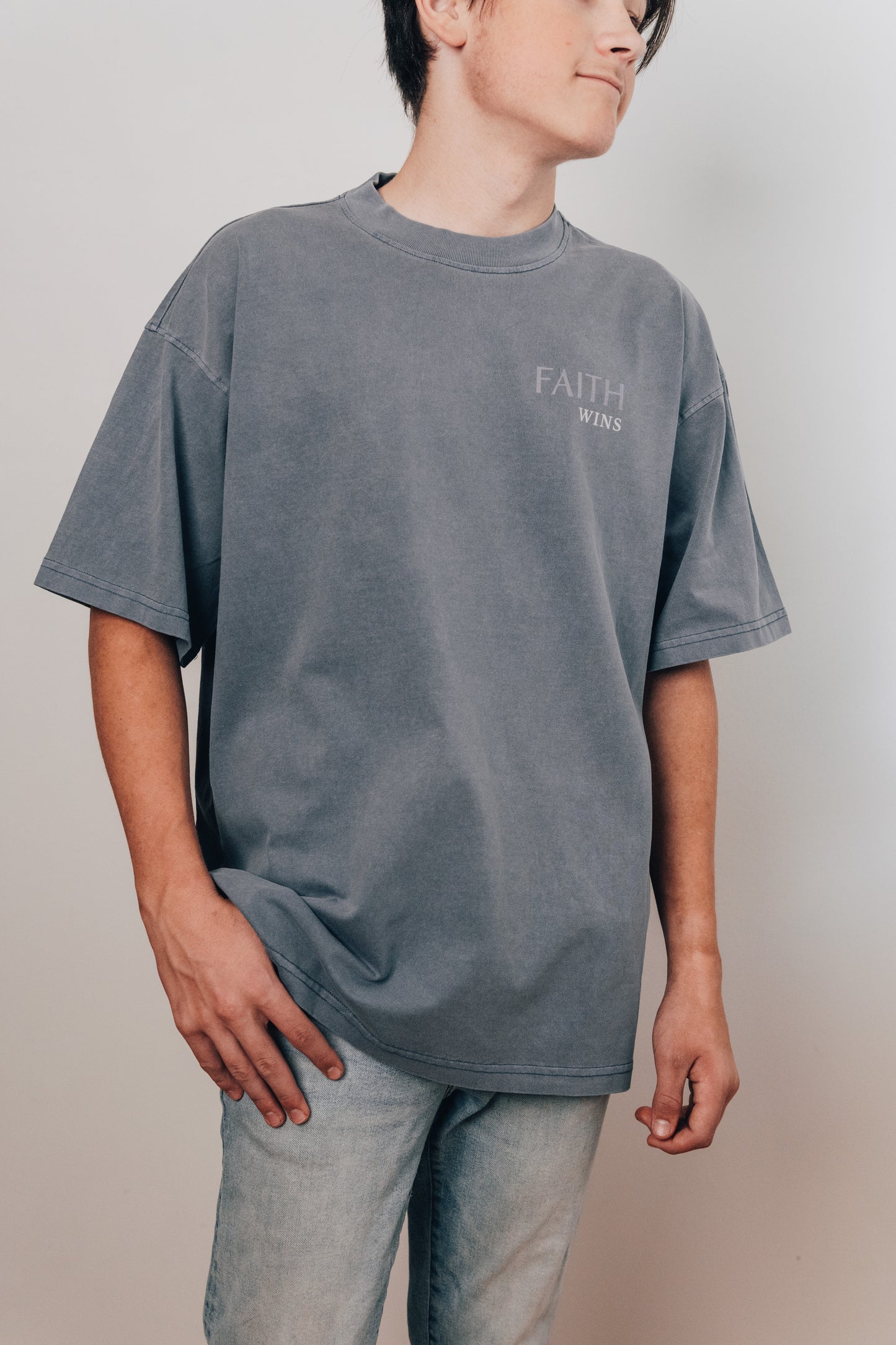 Model wearing faith-based tee in gray color